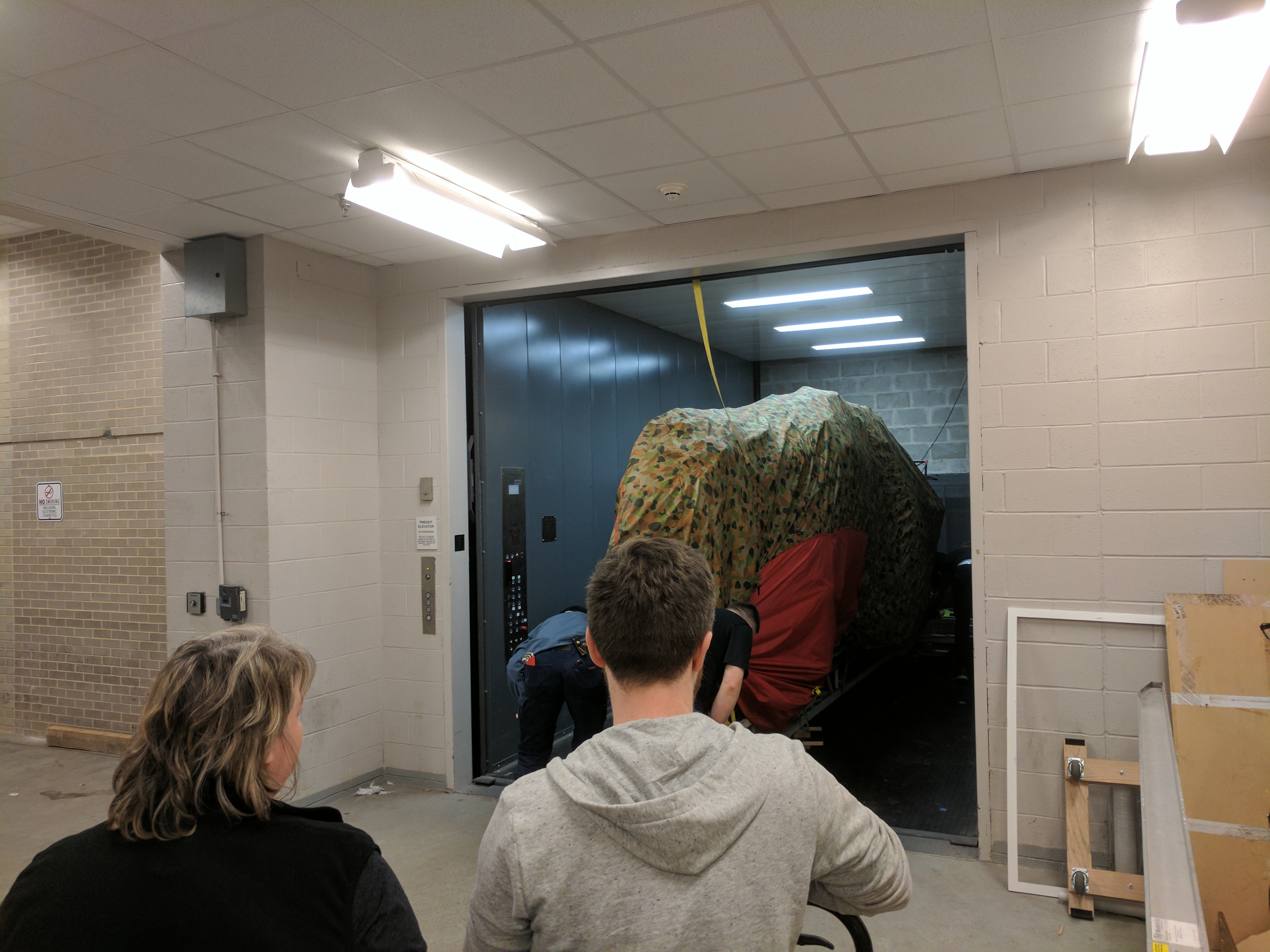 Photograph of a dinosaur model being transported in an elevator for the Jurassic World exhibit in 2016 