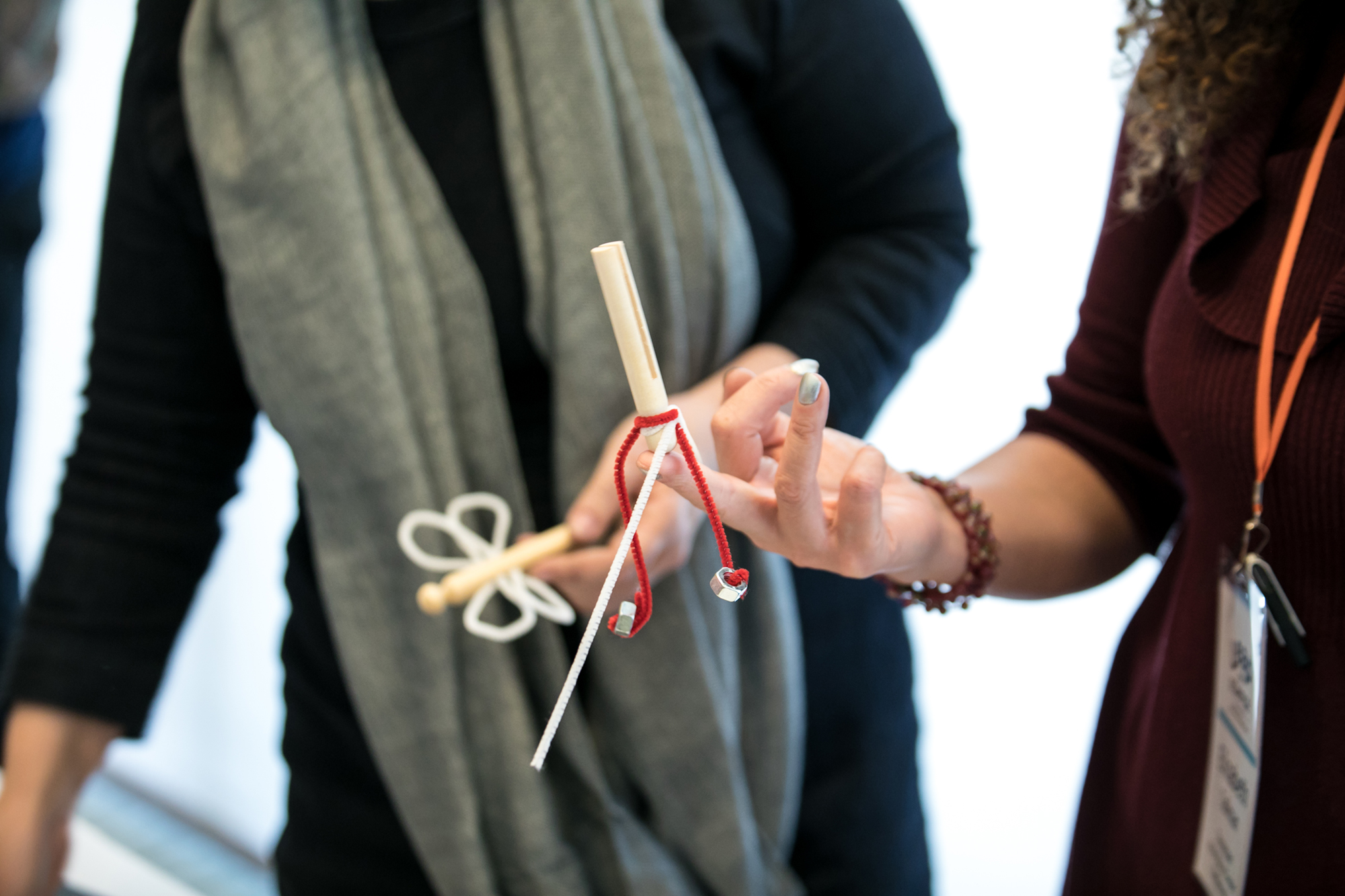 A homemade kinetic sculpture balances on one finger of a hand