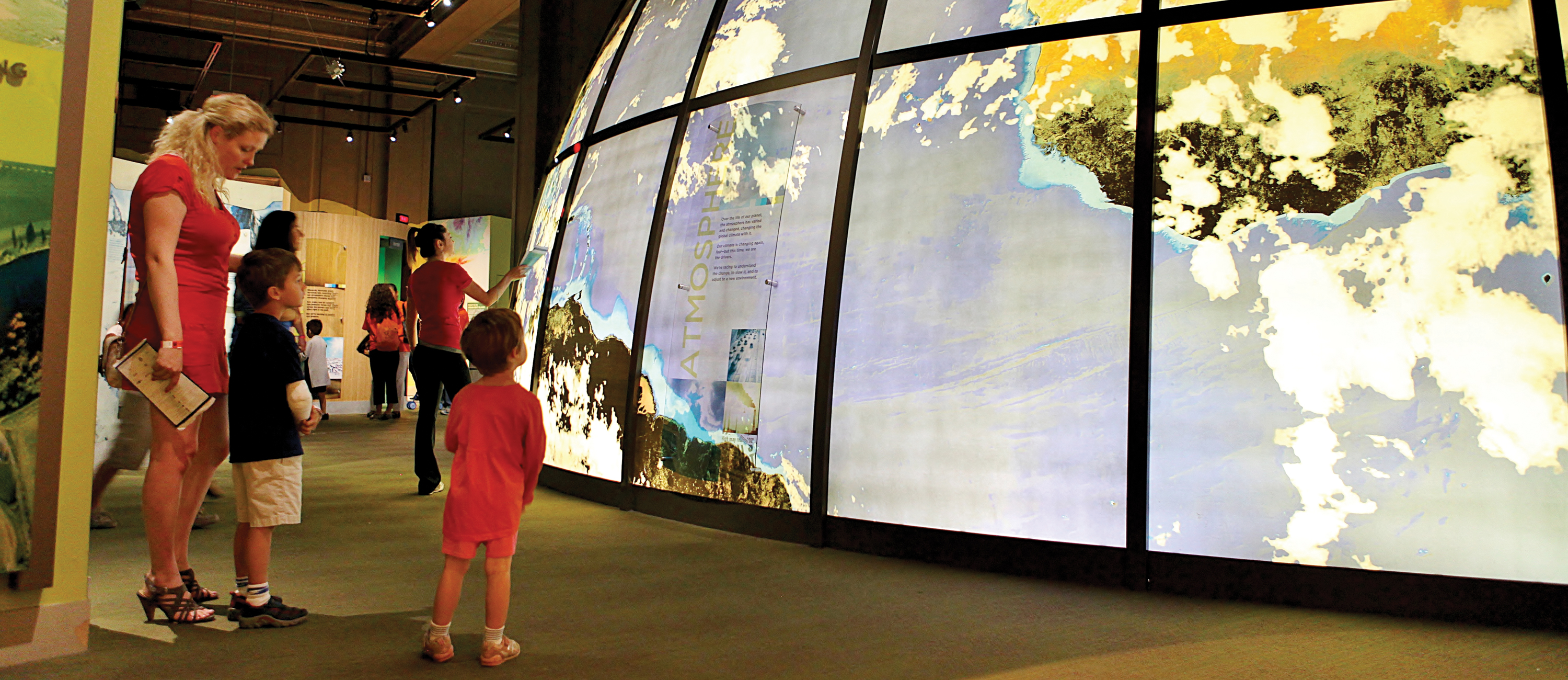 Visitors enjoying the permanent exhibit, Changing Earth. The giant globe in the center of the exhibit can be seen prominently.