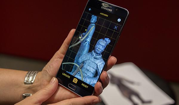 A phone displays 3D models of the Standing and Kneeling Archers, two statues found with the ancient Terracotta Army.