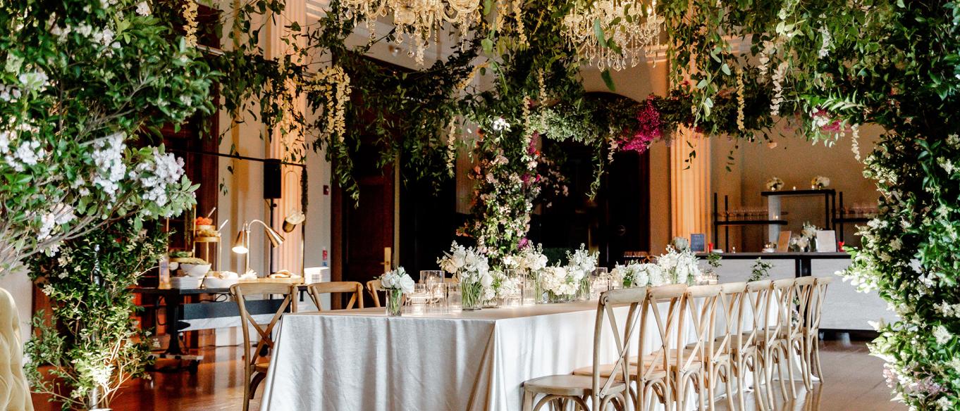Pepper Hall decorated for an event with chandeliers, flowers and lush greenery
