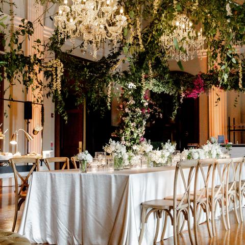 Pepper Hall decorated for an event with chandeliers, flowers and lush greenery